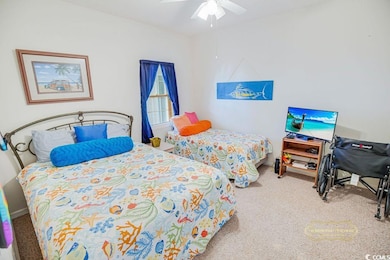 Carpeted bedroom featuring ceiling fan