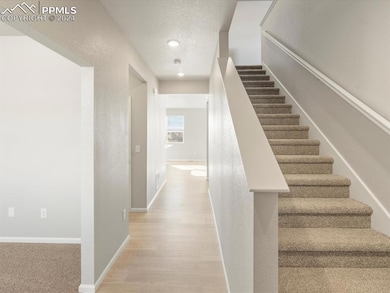 Stairs with wood-type flooring and a textured ceil