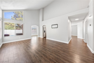 Unfurnished living room with arched walkways, dark