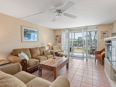 Living area with a wall of windows, ceiling fan, a