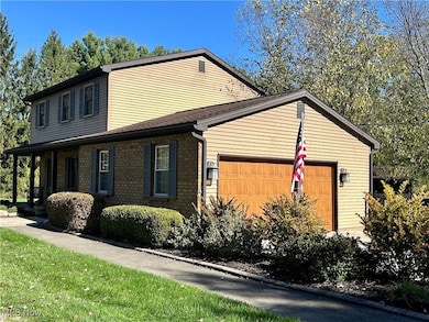 View of side of property with a garage, a yard, and roof with shingles