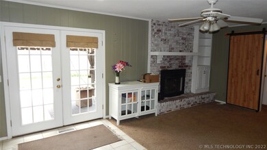Another view of living room with wood burning fire