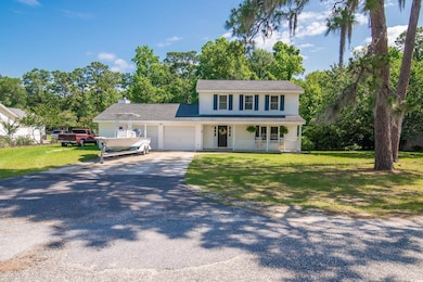 View of front of home with covered porch, a garage, driveway, and a front lawn