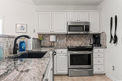 Kitchen featuring light stone countertops, white c