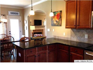 Modern, yet warm kitchen has granite counters & st
