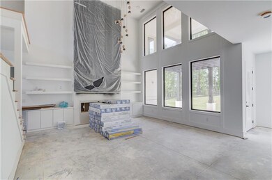 Living room with concrete flooring, a high ceiling