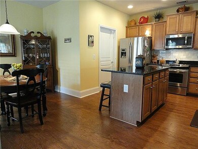 Kitchen with island and pull out shelves.  Beautiful hardwood floors and upgraded cabinets.