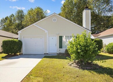 View of front of property with a front lawn, a chimney, and concrete driveway