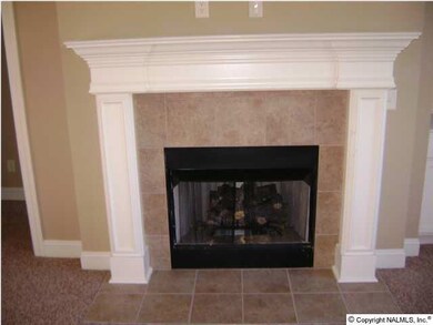 A close view of the custom mantle and ceramic tile hearth. The fireplace is the perfect accent to the great room.