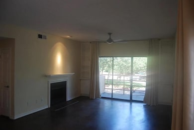 Unfurnished living room with concrete flooring, a fireplace, and a ceiling fan