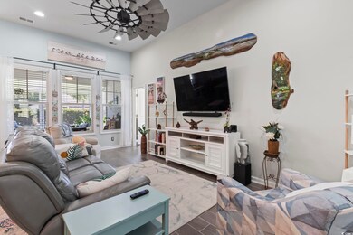 Living room featuring ceiling fan and dark wood-ty