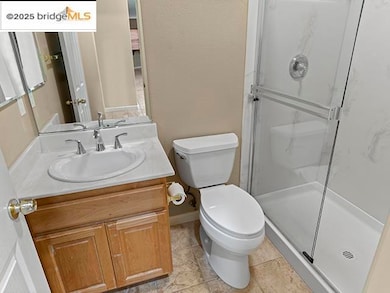 Bathroom with vanity, a marble finish shower, and light tile patterned floors