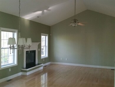 spacious room with vaulted ceiling and fireplace