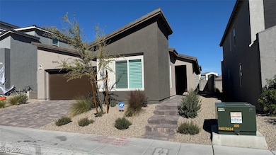 View of front of house with stucco siding and decorative driveway