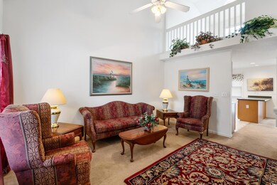 Living room with light colored carpet, ceiling fan