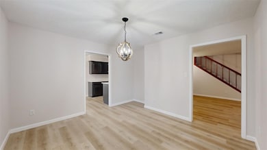 Spare room featuring a chandelier and light hardwo