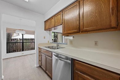 Kitchen with dishwasher, light countertops, brown
