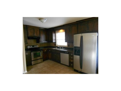 Kitchen has ceramic tile flooring. Tile back splas