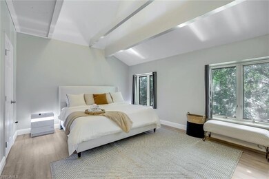 Bedroom with vaulted ceiling with beams and light 