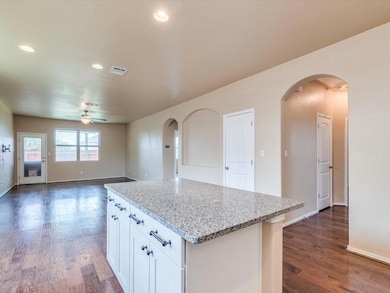 Kitchen with ceiling fan, arched walkways, dark w