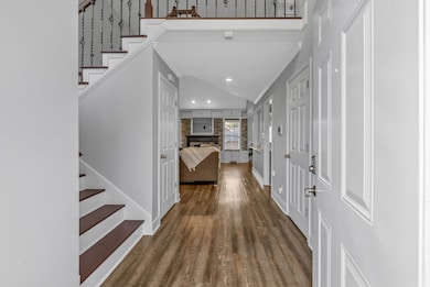 Tall entry foyer and hardwood steps welcome you inside.