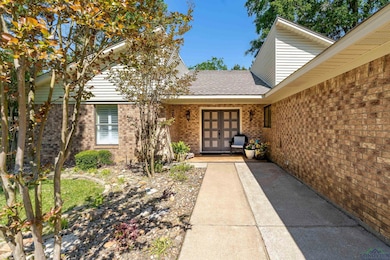 Entrance to property with brick siding and a shingled roof