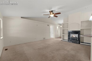 Unfurnished living room with carpet, a multi sided fireplace, ceiling fan, baseboards, and high vaulted ceiling