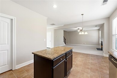 Kitchen with dark brown cabinetry, hanging light fixtures, stainless steel dishwasher, a kitchen island, and open floor plan