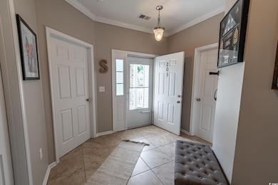 Tiled entrance foyer featuring ornamental molding