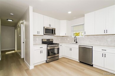 Kitchen featuring stainless steel appliances, white cabinetry, backsplash, light wood-style floors, and recessed lighting