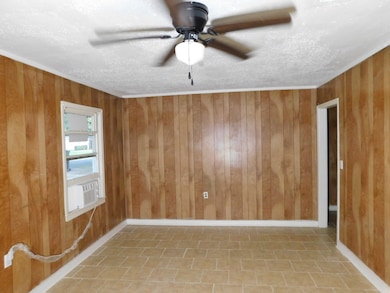 Unfurnished room with wooden walls and ceiling fan
