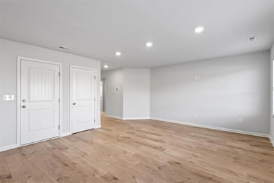 Spare room featuring light wood-type flooring, vis