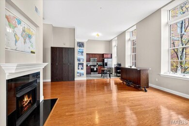 Office area featuring light wood-style floors and a fireplace with flush hearth