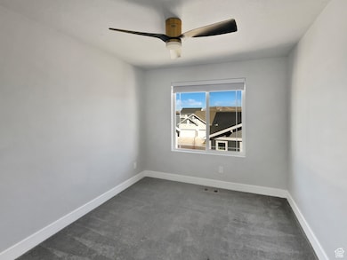 Empty room with baseboards, visible vents, and ceiling fan
