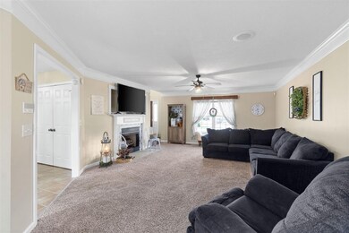Large living room with ceiling fan, crown molding 
