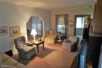 Living room featuring dark carpet and crown molding
