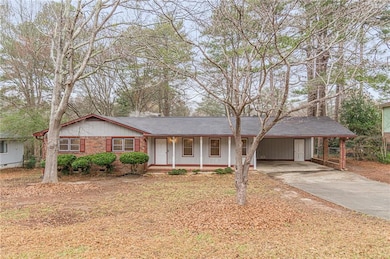 Ranch-style home with concrete driveway, an attached carport, covered porch, and roof with shingles