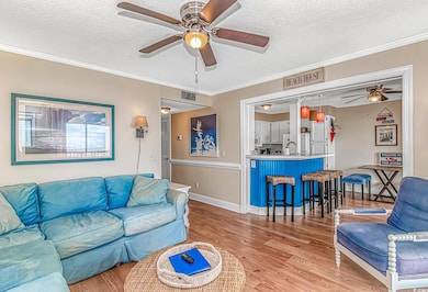 Living room featuring a ceiling fan, a textured ce