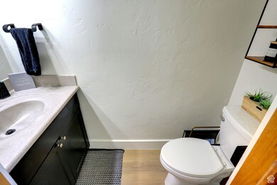 Bathroom featuring vanity, wood finished floors, and a textured wall