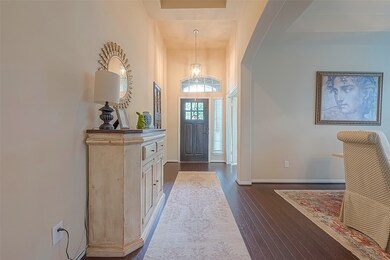 
Looking back toward the front entryway from inside the home, one is greeted by the soft glow of natural light seeping through the windows on the front door and at the entry itself, casting a warm and welcoming ambiance throughout the space. The interplay of light and shadow creates a picturesque scene, inviting residents and guests to pause and appreciate the serene beauty of the home's interior.