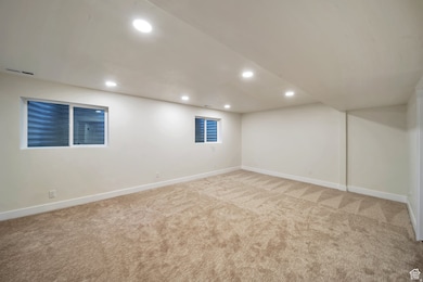 Finished below grade area with recessed lighting and light carpet