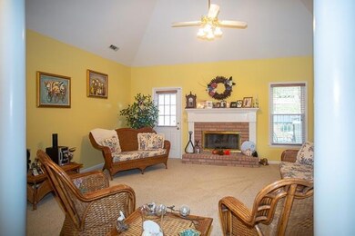 Living room has vaulted ceiling and fireplace with gas logs.