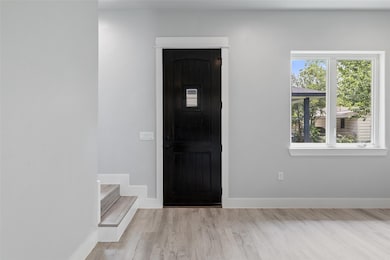 Foyer entrance with baseboards, light wood finish