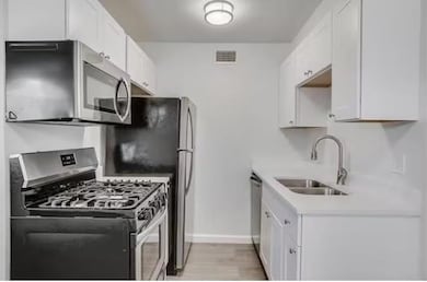 Kitchen featuring white cabinetry, appliances with