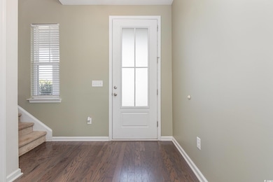 Entryway featuring stairs, baseboards, and dark wo