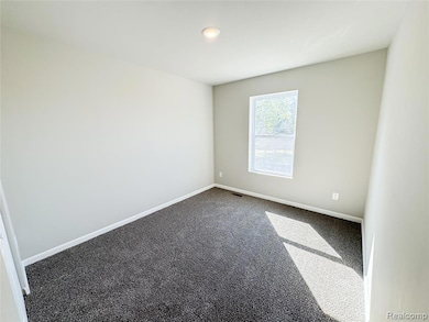 Carpeted empty room featuring baseboards