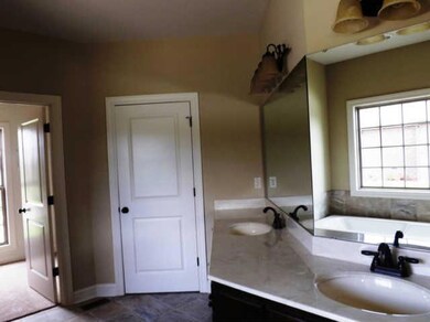 The master bath is huge and features a wraparound double vanity, Jacuzzi tub, separate shower, private toilet and walk-in closet. 