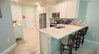 Kitchen with a breakfast bar, sink, white cabinetr