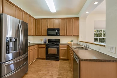 Kitchen featuring black appliances, a sink, dark 
