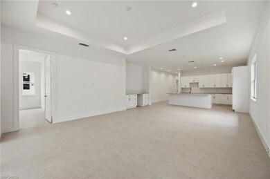 Unfurnished living room with a raised ceiling and recessed lighting